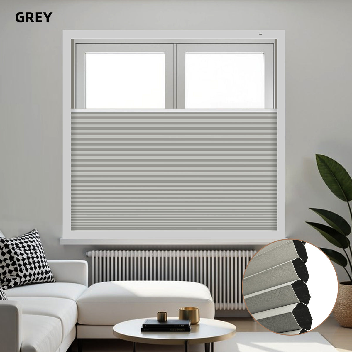 Gray window blackout honeycomb shades in a living room setting with a sofa and plant.