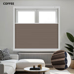 Brown pleated blackout honeycomb shades in a window with a modern living room setting.
