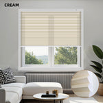 Living room with cream window energy efficient cellular shades, white sofa, and decorative items.