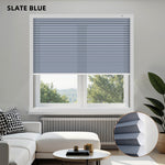 Living room with a window featuring slate blue blinds, white sofa, and decorative items.