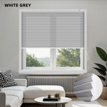 Living room with white gray blinds on a window, sofa, and decor items.