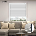 White window custom size cellular blinds in a living room setting with a sofa and decorative elements.