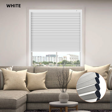 White window custom size cellular blinds in a living room setting with a sofa and decorative elements.