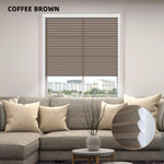 Coffee brown ight filtering cellular shades in a living room setting with a sofa and decorative elements.
