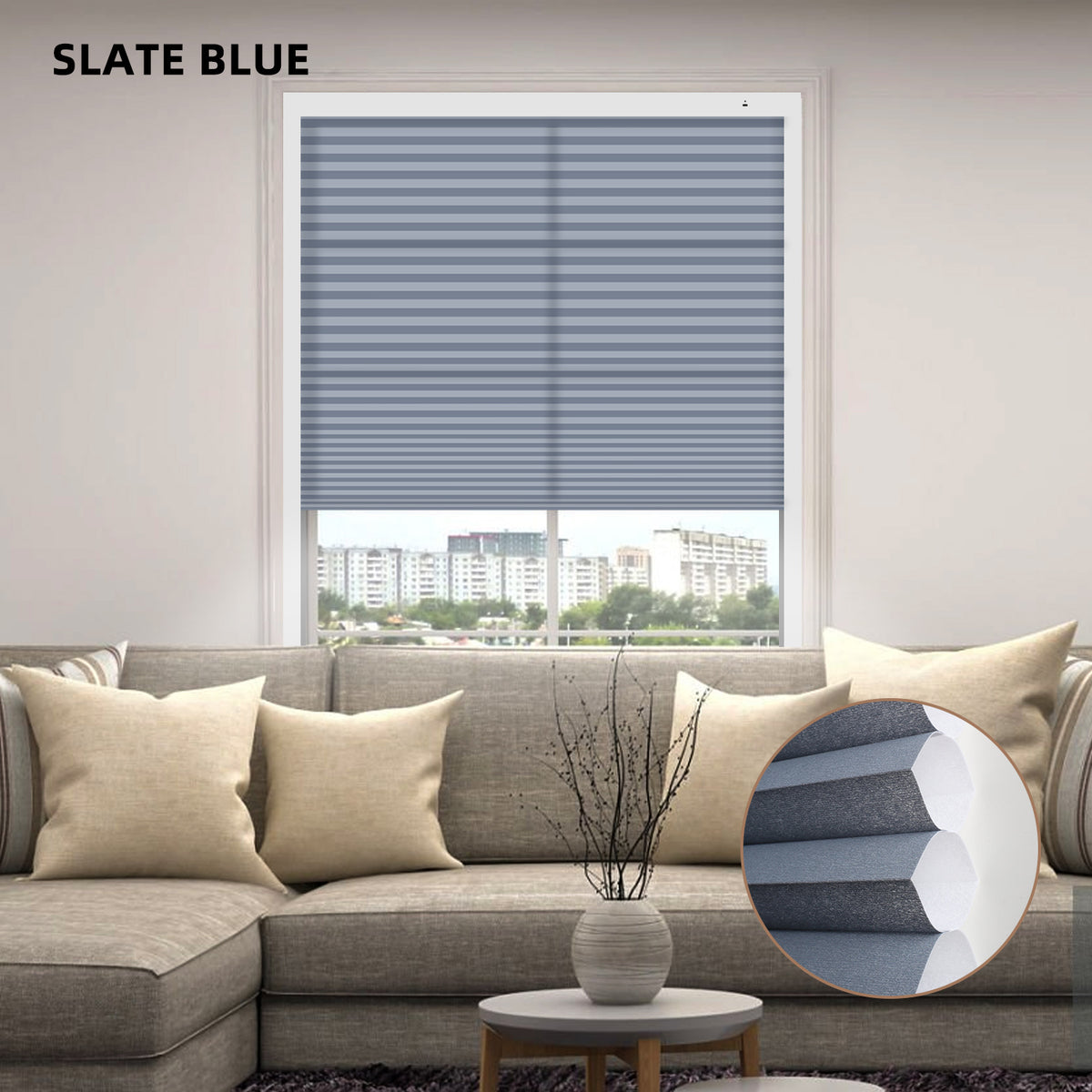 Living room with slate blue motorized cellular honeycomb shades and a round pillow on a sofa.