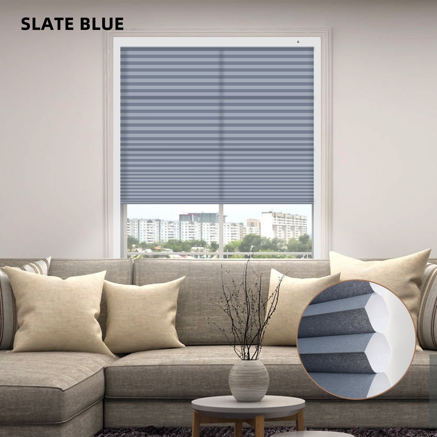 Living room with slate blue motorized cellular honeycomb shades and a round pillow on a sofa.