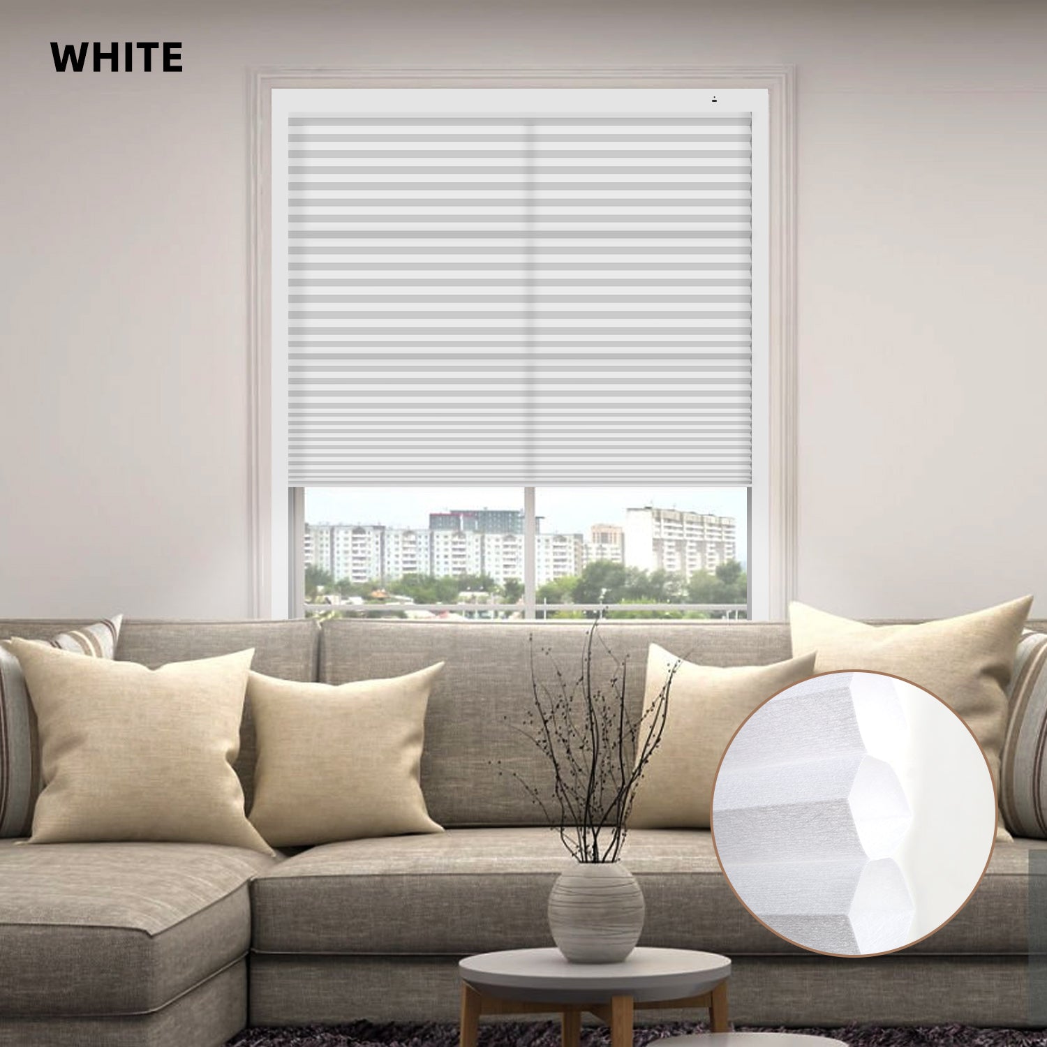 White window motorized cellular honeycomb shades in a living room with a gray sofa and decorative elements.