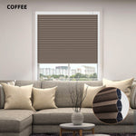 Coffee-colored window honeycomb  blinds in a living room setting with a sofa and decorative elements.