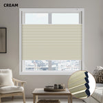 Living room with a window featuring cream-colored blackout cellular shades.