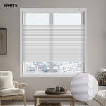 Window with white cellular blinds in a living room setting, showing a close-up of the blinds in the corner.